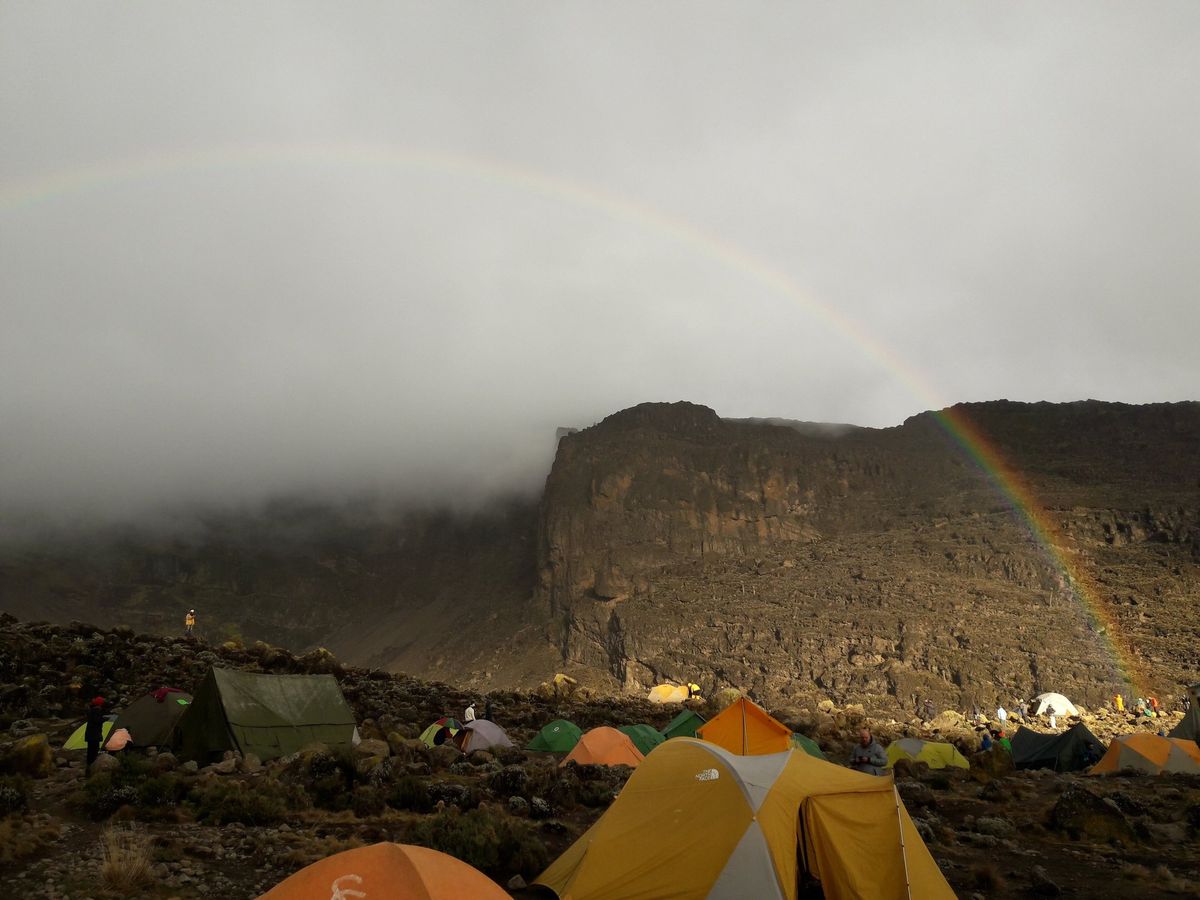 Tents at Barranco Camp beneath the Barranco Wall with a rainbow